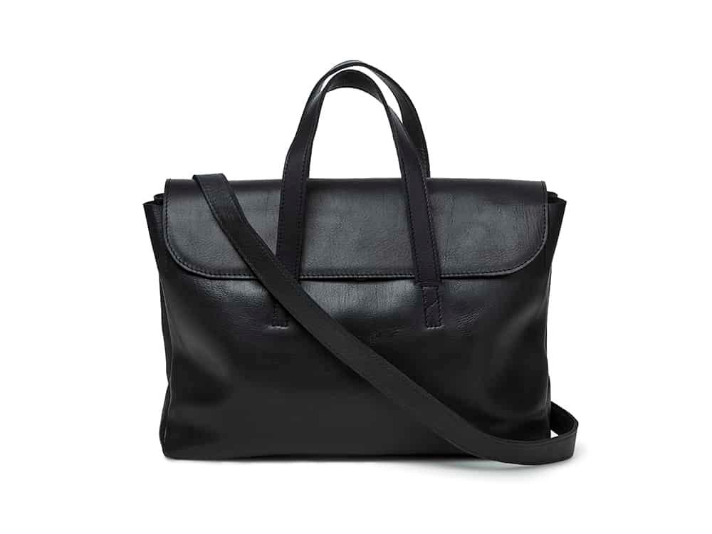 Black leather shoulder bag with top handles and flap closure, minimalist unisex style